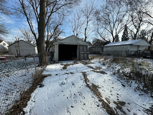 yard covered in snow with a garage and an outbuilding