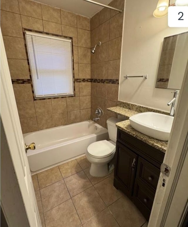 full bathroom featuring vanity, tile patterned flooring, toilet, and tiled shower / bath