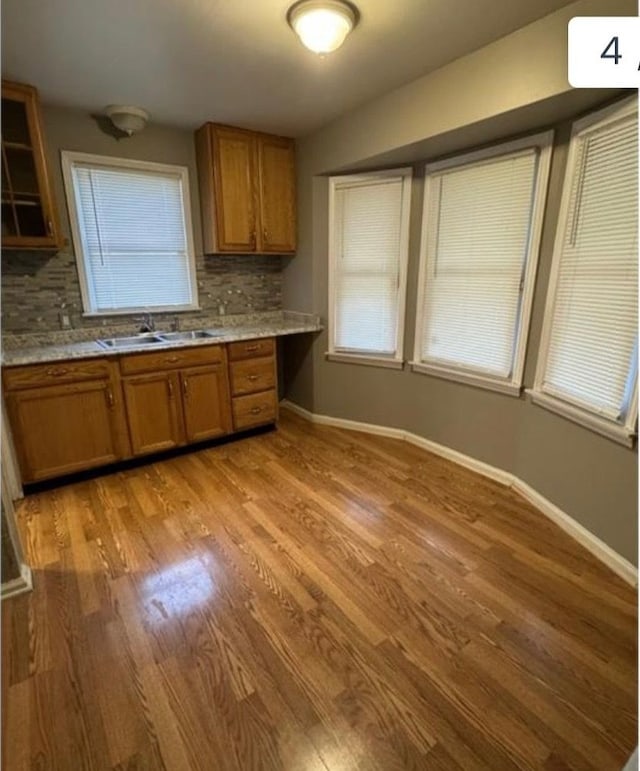 kitchen featuring sink, light hardwood / wood-style flooring, and backsplash