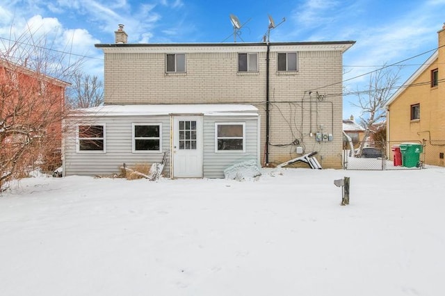 view of snow covered back of property