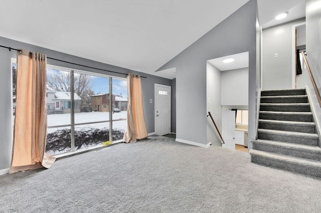 unfurnished living room featuring high vaulted ceiling and carpet flooring