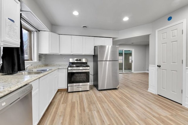 kitchen featuring sink, light hardwood / wood-style flooring, stainless steel appliances, and white cabinets