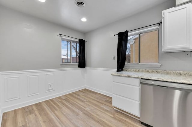 kitchen with light stone counters, stainless steel dishwasher, light hardwood / wood-style floors, and white cabinets