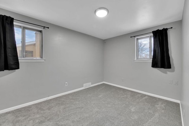 spare room featuring a healthy amount of sunlight and carpet