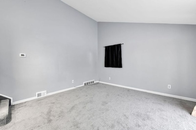 empty room featuring vaulted ceiling and carpet