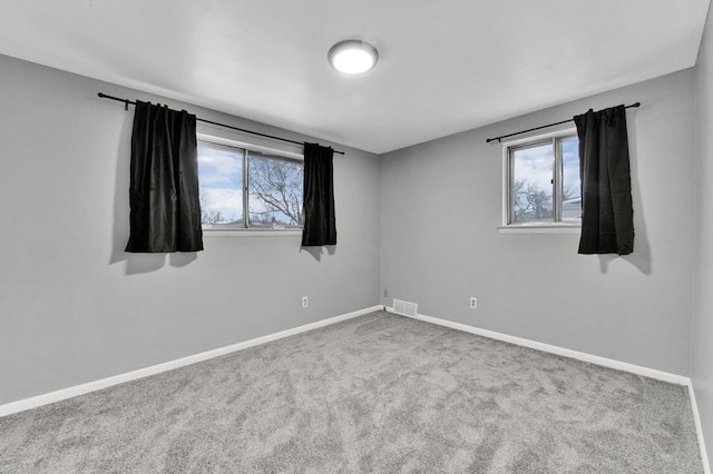 spare room with plenty of natural light and carpet