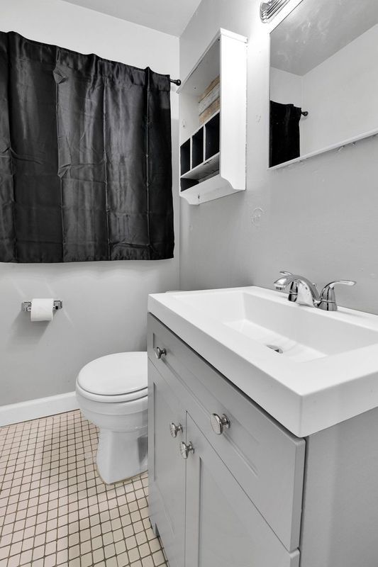 bathroom featuring tile patterned flooring, vanity, and toilet