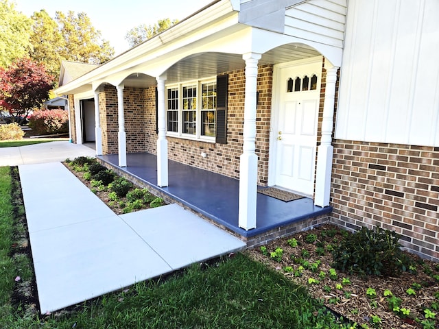 doorway to property with a garage and a porch