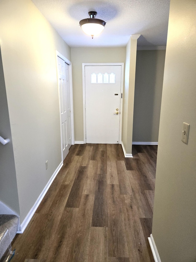 doorway with a textured ceiling and dark hardwood / wood-style flooring