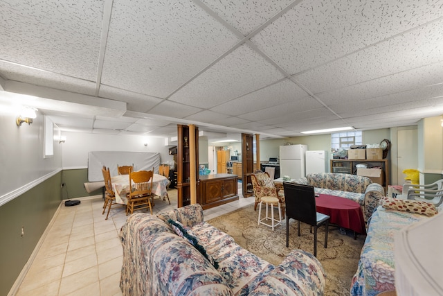 living room featuring a drop ceiling and tile patterned floors