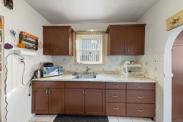 kitchen with sink, backsplash, and light tile patterned flooring