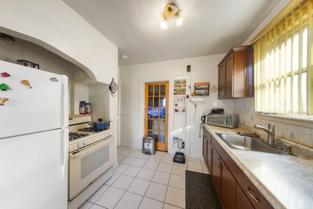 kitchen with sink, light tile patterned floors, white appliances, and decorative backsplash