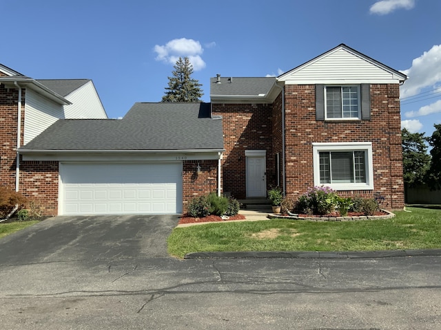 view of property featuring a garage and a front yard