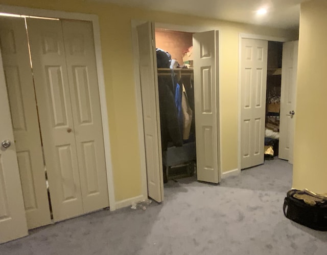 unfurnished bedroom with light carpet and multiple closets