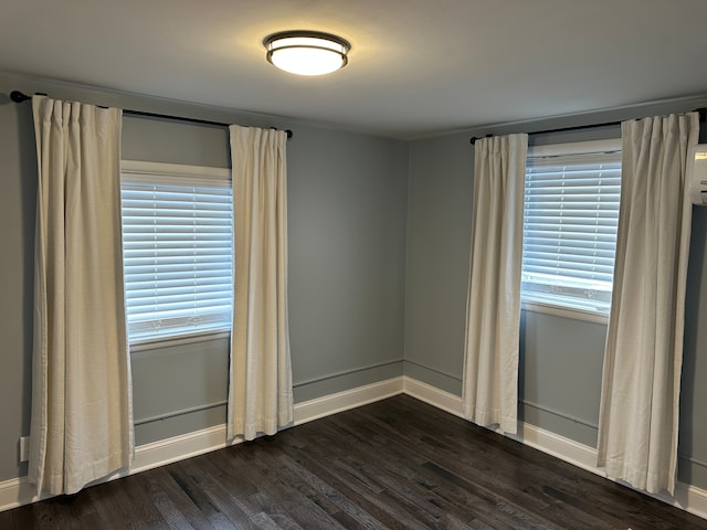 spare room with plenty of natural light and dark hardwood / wood-style floors