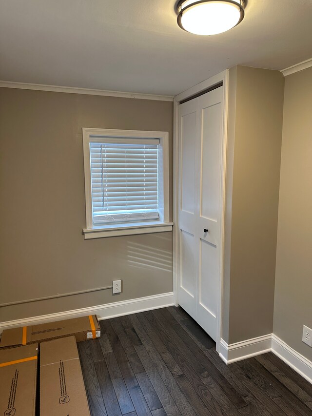 empty room with crown molding and dark hardwood / wood-style floors