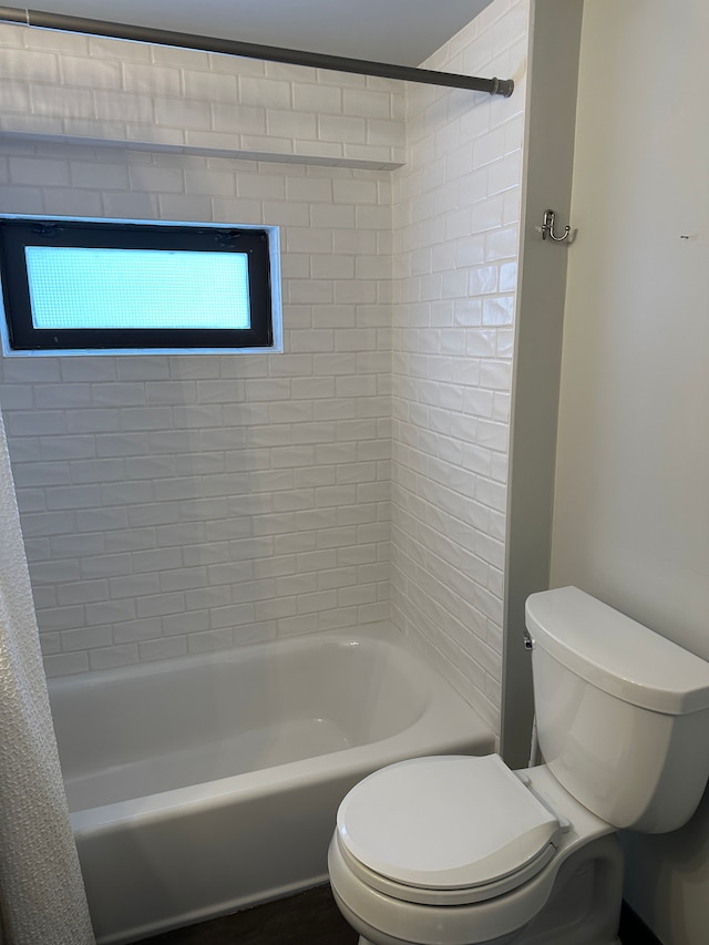 bathroom featuring shower / bath combination with curtain and toilet