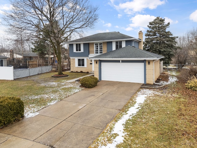 view of property featuring a garage and a front lawn