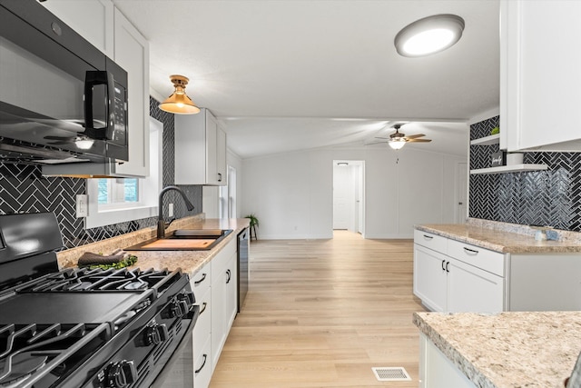 kitchen featuring sink, light stone counters, black appliances, white cabinets, and light wood-type flooring