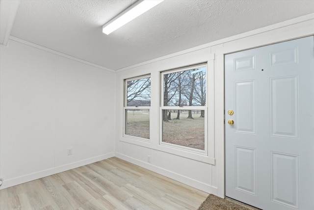 entrance foyer with light hardwood / wood-style floors and a textured ceiling