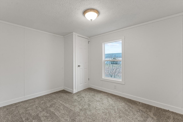 carpeted spare room with a textured ceiling