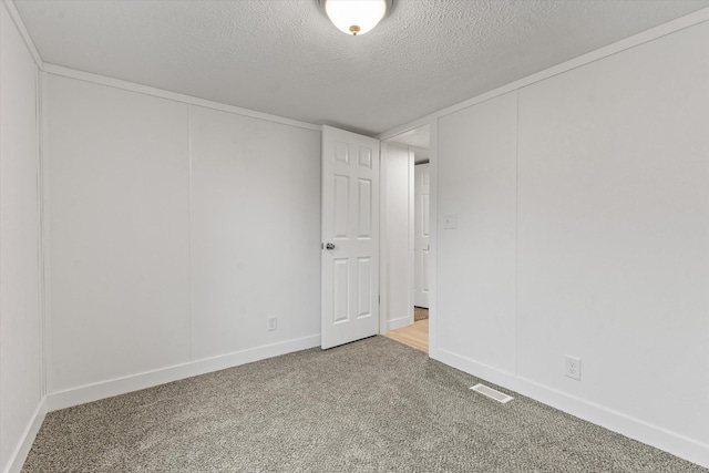 unfurnished room featuring carpet and a textured ceiling