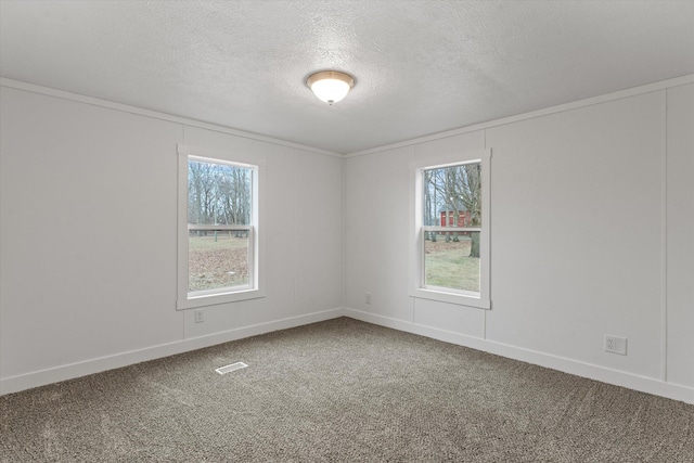 carpeted empty room featuring a textured ceiling