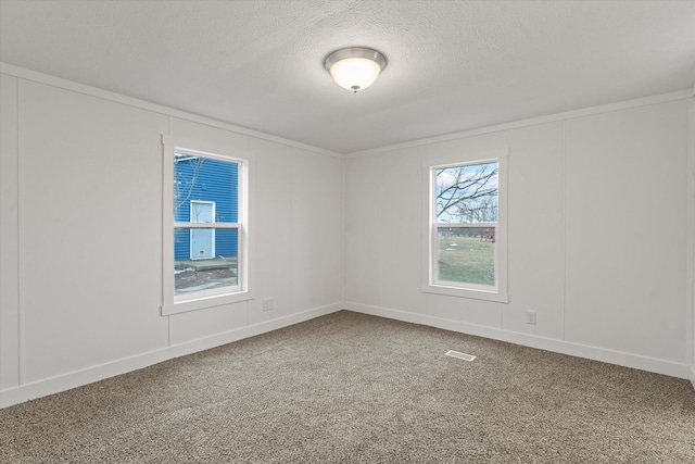 carpeted empty room with a textured ceiling