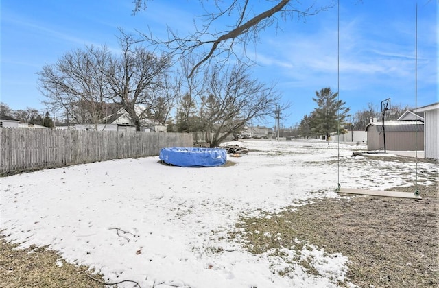 yard layered in snow with a covered pool