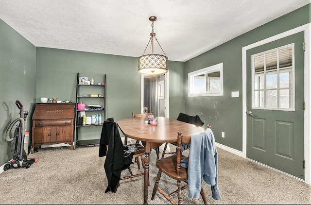 carpeted dining space featuring a textured ceiling