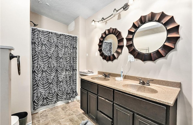 bathroom with a shower with curtain, vanity, and a textured ceiling