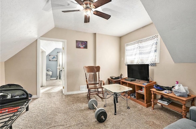 sitting room featuring vaulted ceiling, carpet, ceiling fan, and a textured ceiling