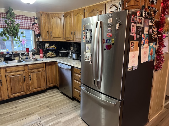 kitchen featuring appliances with stainless steel finishes, light hardwood / wood-style floors, and sink