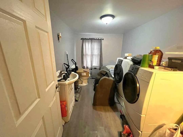 clothes washing area with wood-type flooring and washing machine and dryer