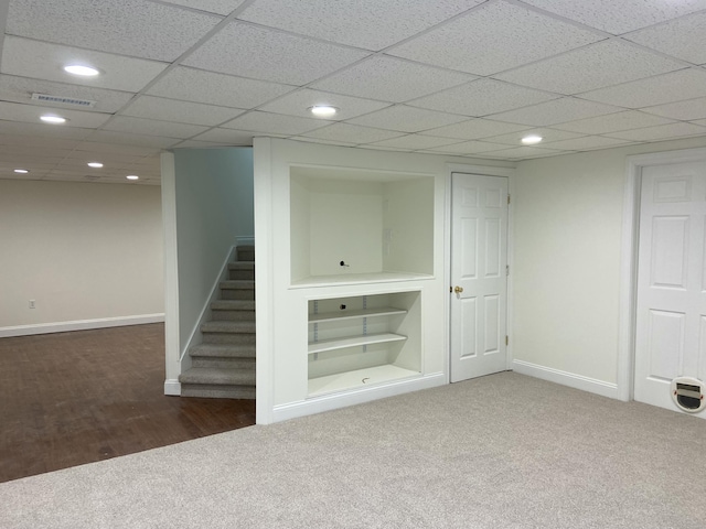 basement with dark carpet and built in shelves