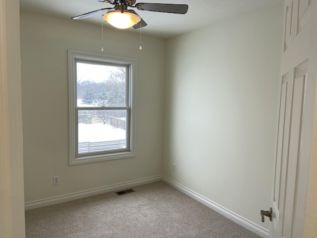 unfurnished room with ceiling fan and carpet