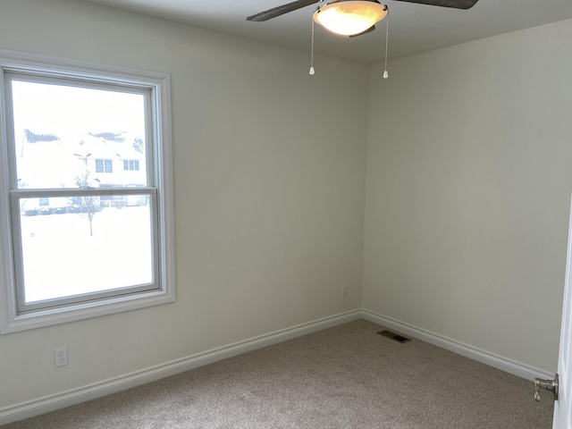 carpeted spare room featuring ceiling fan