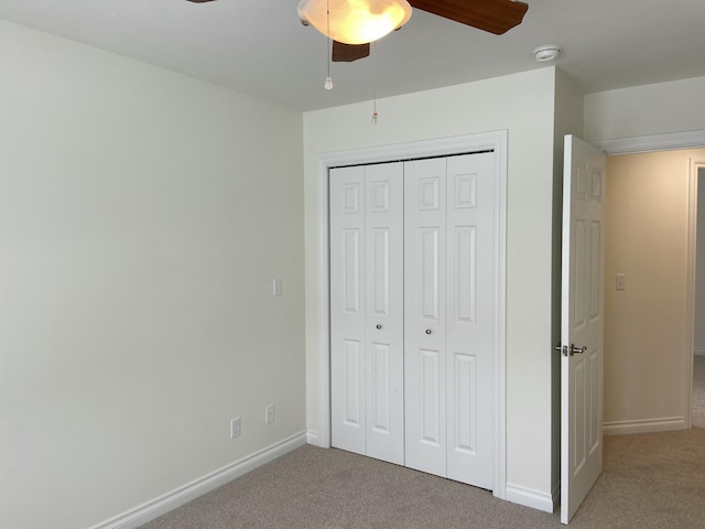 unfurnished bedroom with ceiling fan, carpet flooring, and a closet