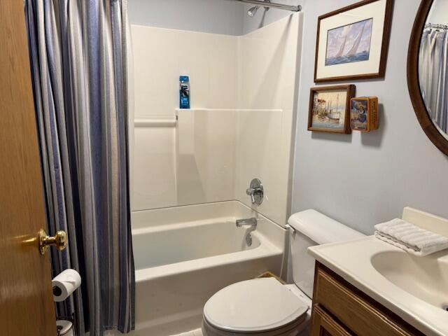 full bathroom with vanity, shower / bathtub combination with curtain, and toilet