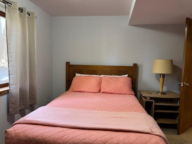 carpeted bedroom featuring multiple windows and lofted ceiling