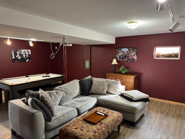 living room with billiards, rail lighting, and hardwood / wood-style floors