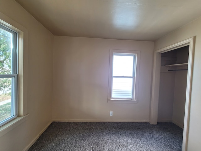 unfurnished bedroom featuring multiple windows and carpet floors