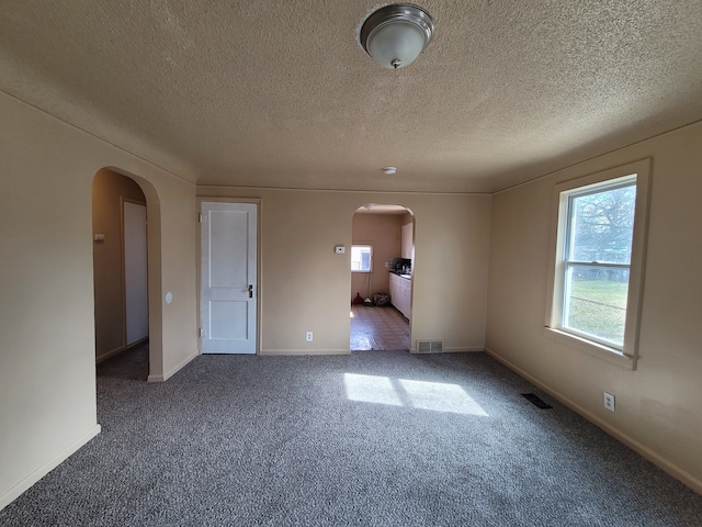 carpeted spare room with a textured ceiling