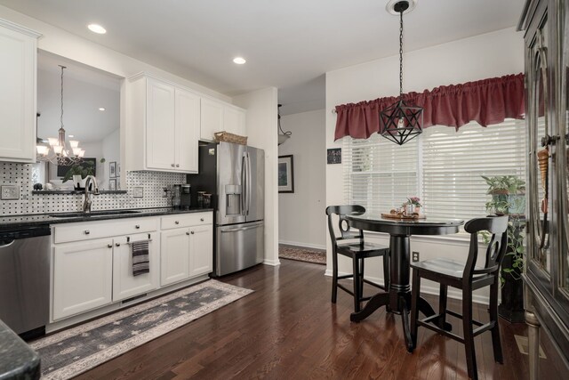 kitchen featuring hanging light fixtures, appliances with stainless steel finishes, sink, and white cabinets