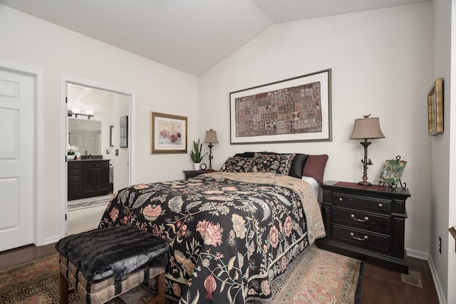 bedroom featuring ensuite bath, dark hardwood / wood-style floors, and vaulted ceiling