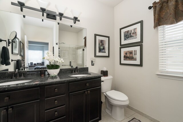 bathroom featuring vanity, toilet, a shower with shower door, and tile patterned flooring