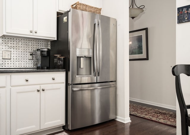 kitchen with stainless steel refrigerator with ice dispenser, dark wood-type flooring, tasteful backsplash, and white cabinets