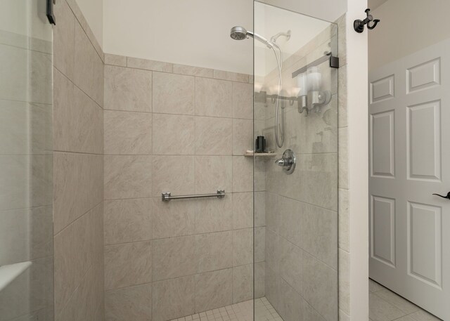 bathroom with tile patterned flooring and tiled shower