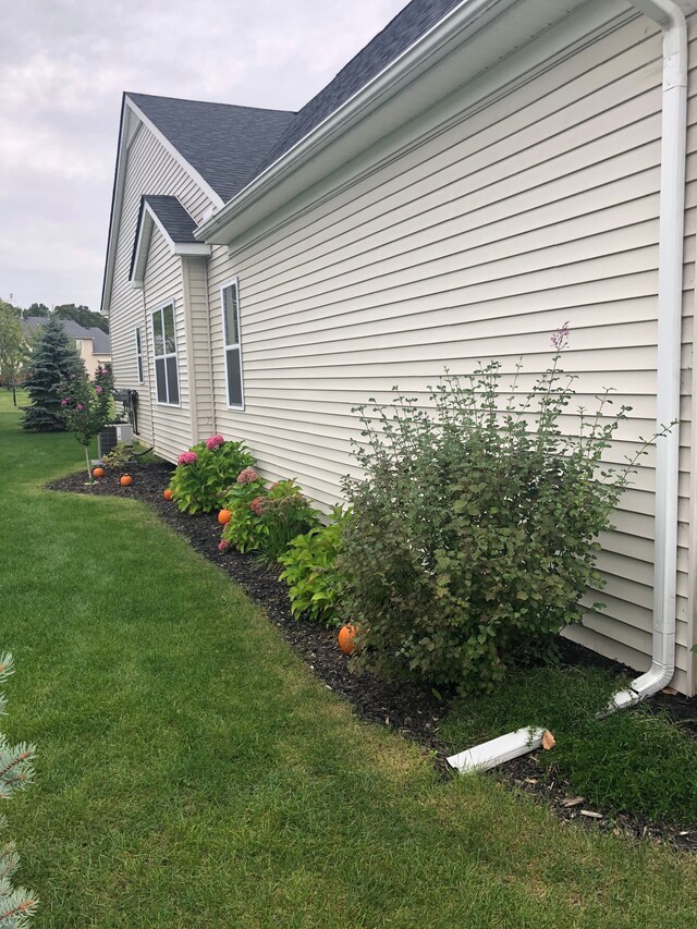 view of property exterior with a yard and cooling unit