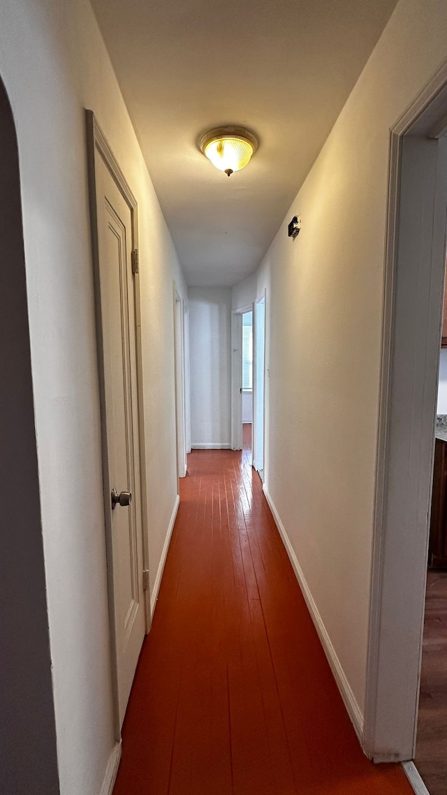 corridor with hardwood / wood-style flooring